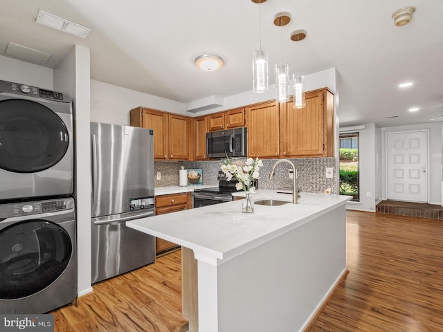 1806 Bryant St NE Unit 1806, Washington, DC 20018 - kitchen with stainless steel appliances, estacked washer and dryer, a sink, a peninsula, and light countertops