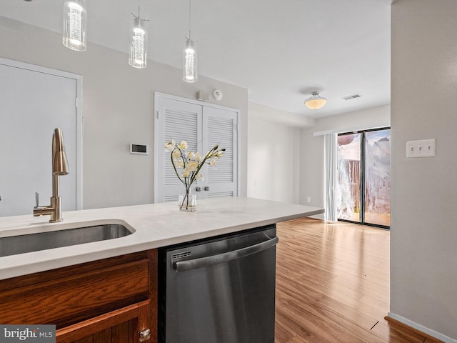 1806 Bryant St NE Unit 1806, Washington, DC 20018 - kitchen with stainless steel dishwasher, a sink, light countertops, wood finished floors, and pendant lighting