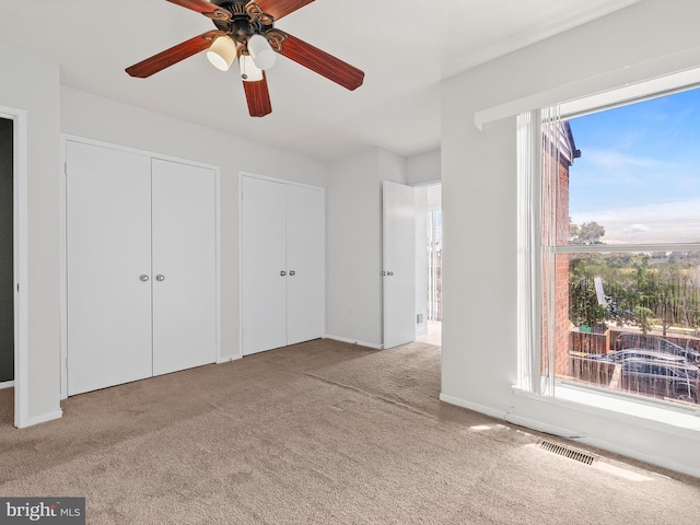 1806 Bryant St NE Unit 1806, Washington, DC 20018 - unfurnished bedroom with carpet, two closets, ceiling fan, and baseboards