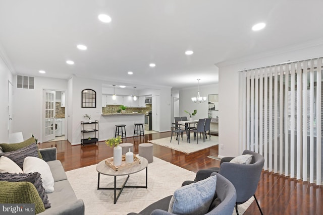 29 Stonehenge Cir Unit 6, Pikesville, MD 21208 - living room featuring ornamental molding, recessed lighting, wood finished floors, washer / dryer, and a chandelier
