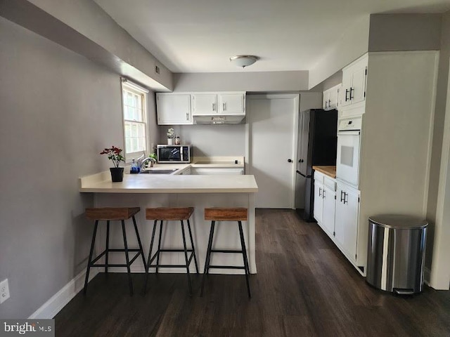15709 Presswick Ln, Bowie, MD 20716 - kitchen with stainless steel microwave, oven, a peninsula, freestanding refrigerator, and under cabinet range hood