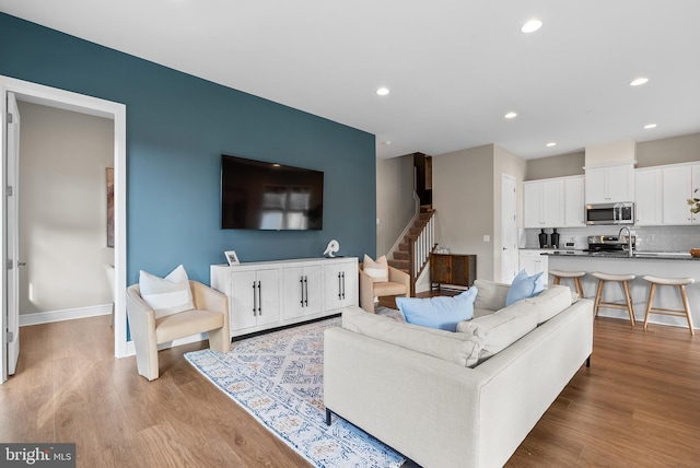 25493 Grassy Meadow Dr, Aldie, VA 20105 - living room featuring stairs, light wood-style floors, recessed lighting, and baseboards