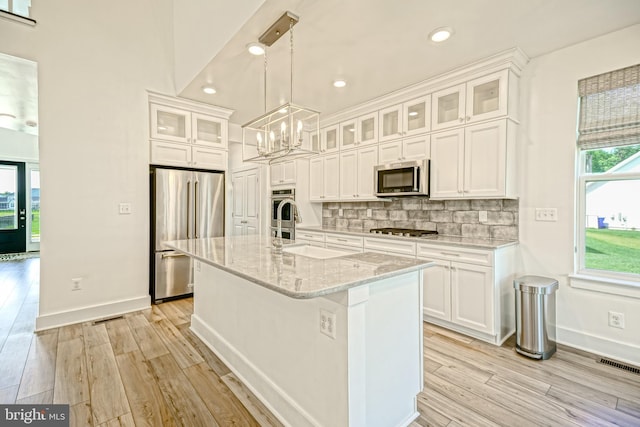 35024 Black Walnut Dr, Lewes, DE 19958 - kitchen featuring stainless steel appliances, light wood-type flooring, a chandelier, baseboards, and decorative backsplash