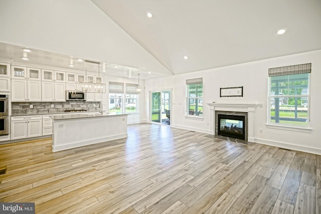 35024 Black Walnut Dr, Lewes, DE 19958 - unfurnished living room with a high end fireplace, healthy amount of natural light, light wood-style flooring, a sink, and recessed lighting