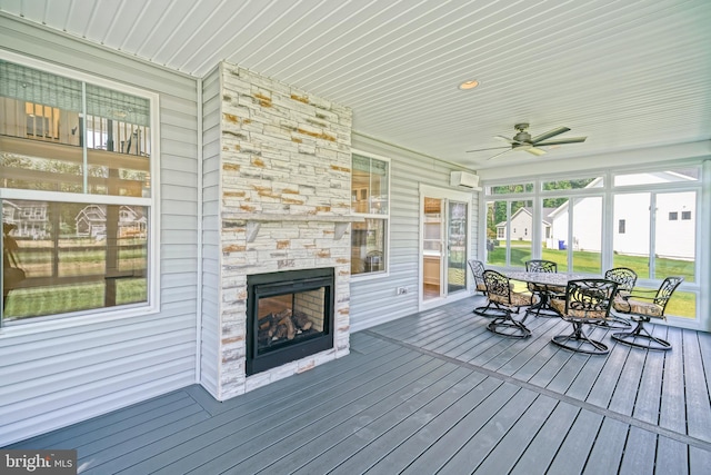 35024 Black Walnut Dr, Lewes, DE 19958 - wooden deck featuring a wall unit AC, outdoor dining area, a ceiling fan, and a stone fireplace