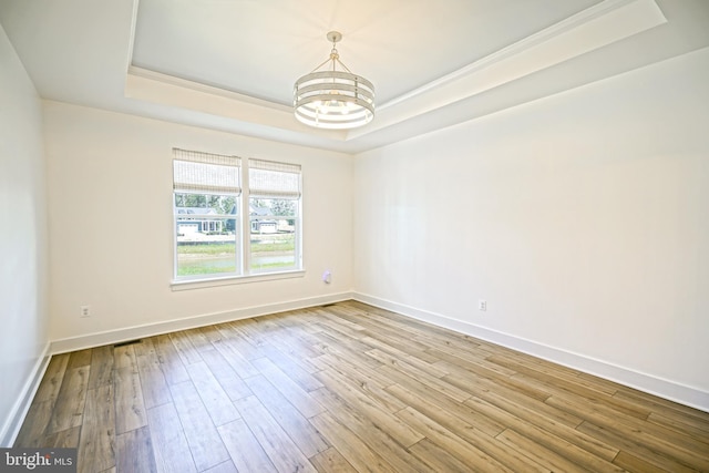 35024 Black Walnut Dr, Lewes, DE 19958 - unfurnished room with a tray ceiling, a chandelier, wood finished floors, and ornamental molding
