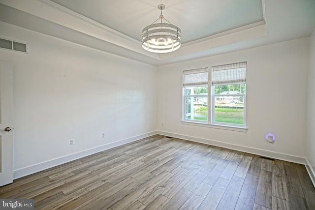 35024 Black Walnut Dr, Lewes, DE 19958 - empty room with a tray ceiling, a chandelier, wood finished floors, and baseboards
