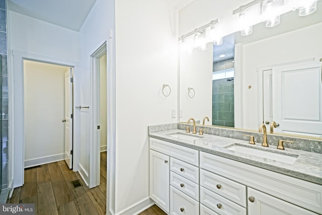 35024 Black Walnut Dr, Lewes, DE 19958 - full bath with double vanity, wood finished floors, a tile shower, and baseboards