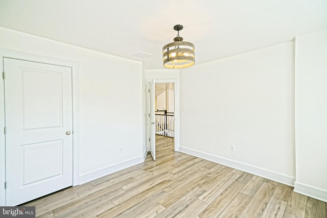 35024 Black Walnut Dr, Lewes, DE 19958 - unfurnished room with light wood-type flooring, baseboards, and a chandelier