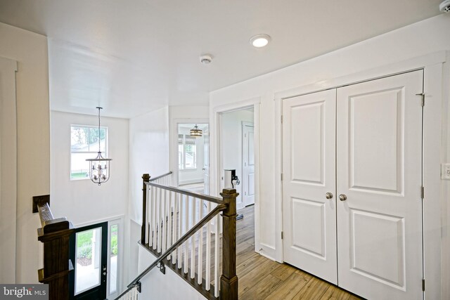 35024 Black Walnut Dr, Lewes, DE 19958 - corridor featuring an upstairs landing, a chandelier, and light wood-style floors