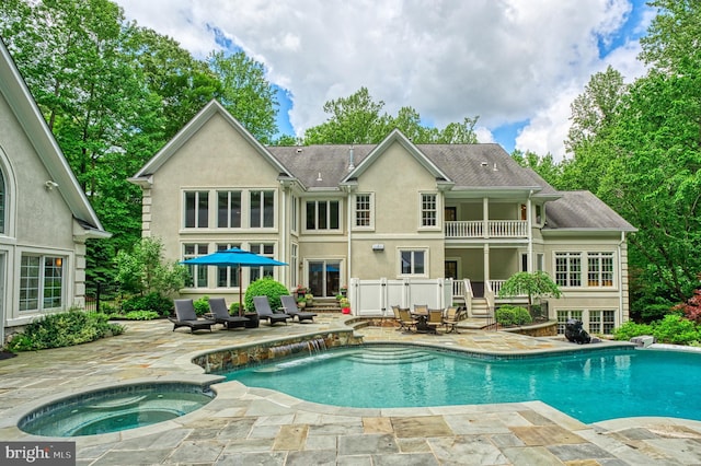 5026 Huntwood Manor Dr, Fairfax, VA 22030 - rear view of property with an in-ground hot tub, a balcony, a patio area, an outdoor pool, and stucco siding