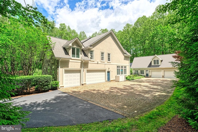 5026 Huntwood Manor Dr, Fairfax, VA 22030 - view of front facade featuring stucco siding, driveway, and a garage