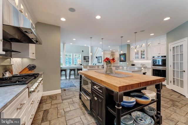 5026 Huntwood Manor Dr, Fairfax, VA 22030 - kitchen with under cabinet range hood, wood counters, appliances with stainless steel finishes, stone tile floors, and recessed lighting