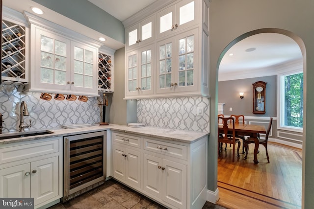 5026 Huntwood Manor Dr, Fairfax, VA 22030 - indoor wet bar featuring beverage cooler, ornamental molding, arched walkways, decorative backsplash, and recessed lighting