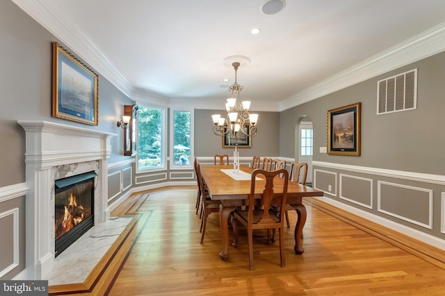 5026 Huntwood Manor Dr, Fairfax, VA 22030 - dining room with light wood-style floors, a decorative wall, a chandelier, ornamental molding, and a fireplace