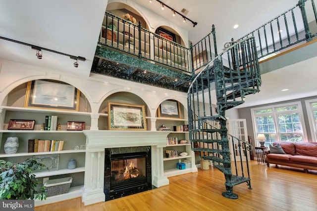 5026 Huntwood Manor Dr, Fairfax, VA 22030 - stairs with track lighting, a high ceiling, wood finished floors, and a glass covered fireplace