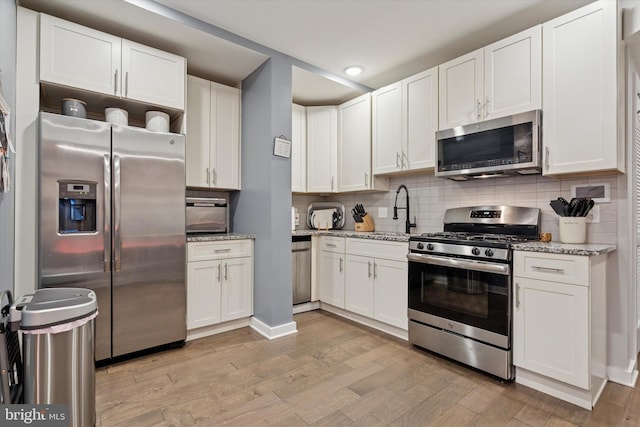 1843 N 6th St Unit 9, Philadelphia, PA 19122 - kitchen featuring stainless steel appliances, a sink, light wood-style floors, white cabinetry, and recessed lighting