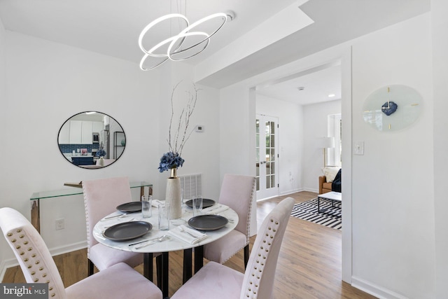 2318 Cloville Ave, Baltimore, MD 21214 - dining area with wood finished floors, a chandelier, baseboards, and french doors