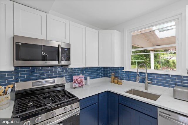 2318 Cloville Ave, Baltimore, MD 21214 - kitchen featuring stainless steel appliances, a sink, white cabinets, and tasteful backsplash