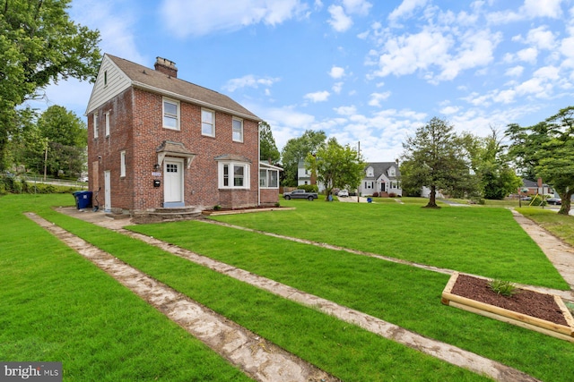 2318 Cloville Ave, Baltimore, MD 21214 - view of front of home with brick siding, a chimney, and a front yard