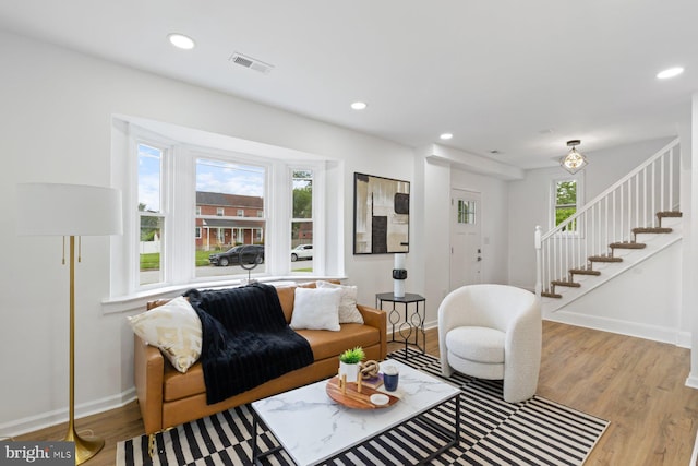 2318 Cloville Ave, Baltimore, MD 21214 - living area featuring wood finished floors, stairs, baseboards, and recessed lighting