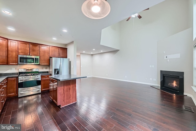 4827 Atlas Cedar Way, Aberdeen, MD 21001 - kitchen featuring stainless steel appliances, open floor plan, dark countertops, a glass covered fireplace, and recessed lighting