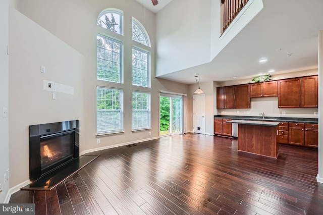 4827 Atlas Cedar Way, Aberdeen, MD 21001 - kitchen with a towering ceiling, a center island, dark countertops, a glass covered fireplace, and open floor plan