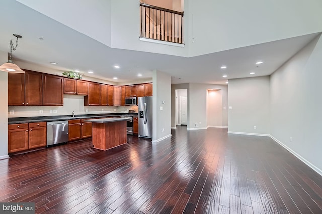 4827 Atlas Cedar Way, Aberdeen, MD 21001 - kitchen with stainless steel appliances, dark countertops, dark wood-style flooring, a center island, and a sink