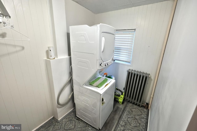 310 E S St, York, PA 17403 - laundry area with radiator heating unit, stacked washer and clothes dryer, and wooden walls