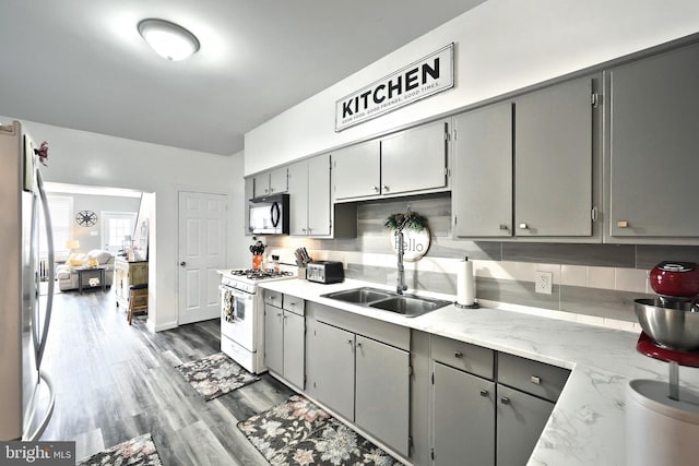 310 E S St, York, PA 17403 - kitchen featuring black microwave, white range with gas stovetop, gray cabinetry, freestanding refrigerator, and a sink