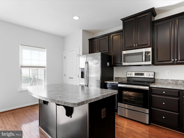 100 Norwood Dr, Falling Waters, WV 25419 - kitchen with appliances with stainless steel finishes, dark wood-style floors, a kitchen island, a breakfast bar, and recessed lighting