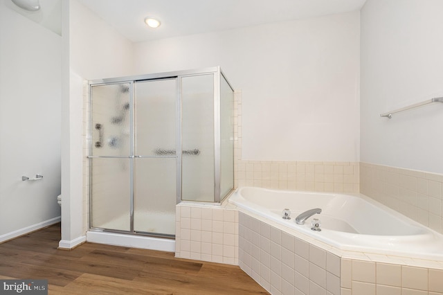 3839 Mulberry Point Ct, Dumfries, VA 22025 - bathroom with a bath, a stall shower, toilet, wood finished floors, and baseboards