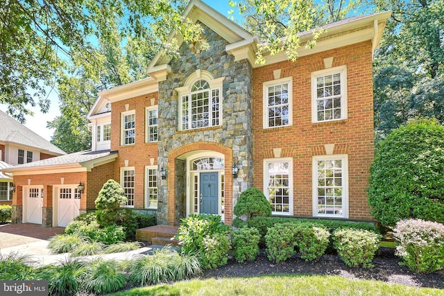3530 Schuerman House Dr, Fairfax, VA 22031 - colonial inspired home featuring stone siding, an attached garage, decorative driveway, and brick siding