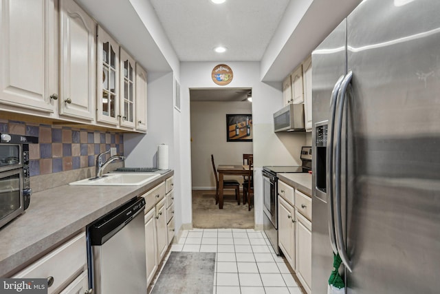700 Avondale Rd Unit Ph-12, Wallingford, PA 19086 - kitchen featuring appliances with stainless steel finishes, a sink, light tile patterned floors, recessed lighting, and glass insert cabinets