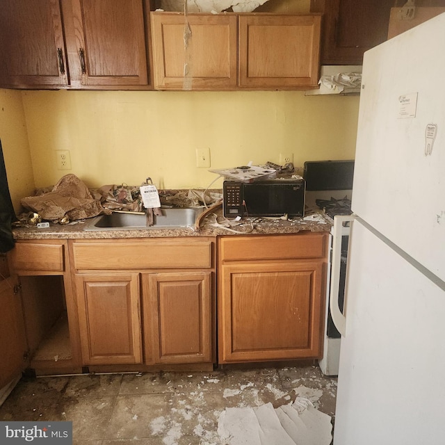 2513 Iverson St, Temple Hills, MD 20748 - kitchen with freestanding refrigerator, black microwave, a sink, extractor fan, and brown cabinetry
