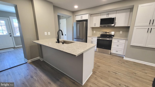 248 W Edgevale Rd, Baltimore, MD 21225 - kitchen featuring appliances with stainless steel finishes, a sink, white cabinets, light wood-type flooring, and recessed lighting
