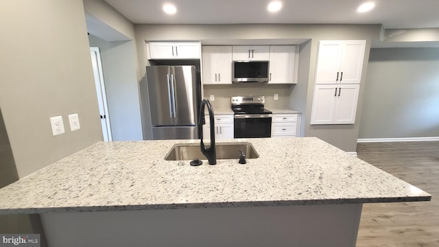 248 W Edgevale Rd, Baltimore, MD 21225 - kitchen with appliances with stainless steel finishes, a sink, white cabinetry, wood finished floors, and light stone countertops