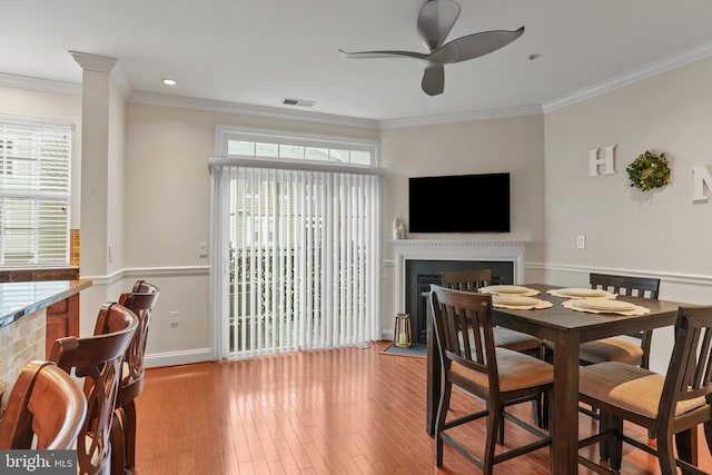 11249 Chase St Unit 100, Fulton, MD 20759 - dining area featuring a fireplace, a ceiling fan, ornamental molding, wood finished floors, and baseboards