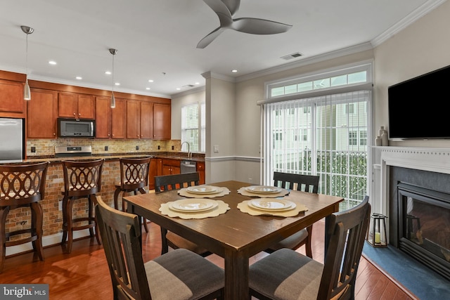 11249 Chase St Unit 100, Fulton, MD 20759 - dining space with dark wood-style flooring, ceiling fan, crown molding, recessed lighting, and a glass covered fireplace