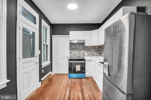 342 W Gay Ave, York, PA 17401 - kitchen with freestanding refrigerator, electric range, under cabinet range hood, white cabinets, and light wood finished floors