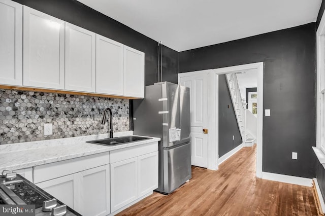 342 W Gay Ave, York, PA 17401 - kitchen featuring a sink, light wood-type flooring, white cabinetry, and baseboards