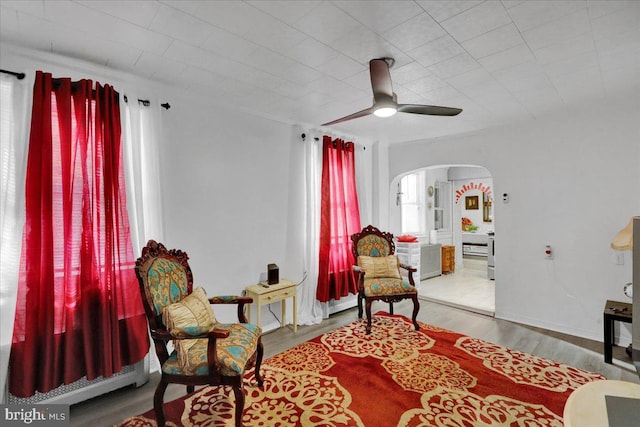 542 S 12th St, Reading, PA 19602 - sitting room with arched walkways, a ceiling fan, wood finished floors, and a baseboard radiator