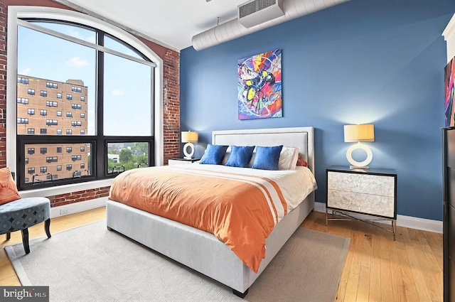 41 W Lemon St Unit 505, Lancaster, PA 17603 - bedroom featuring brick wall, multiple windows, wood-type flooring, and baseboards