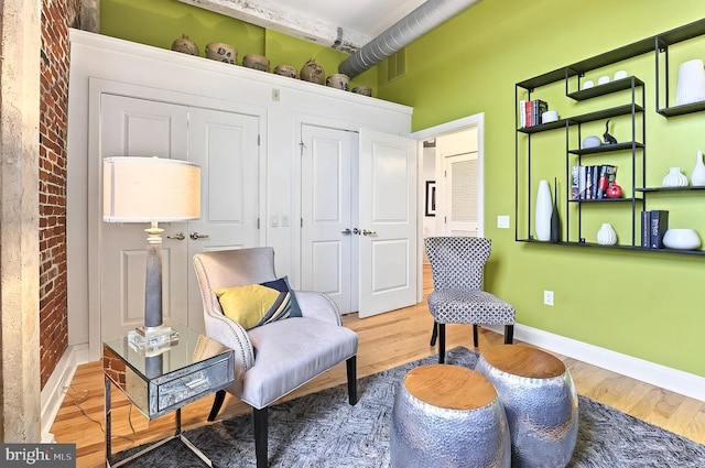 41 W Lemon St Unit 505, Lancaster, PA 17603 - sitting room with light wood-style flooring, baseboards, and brick wall