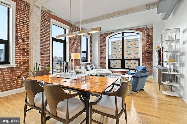 41 W Lemon St Unit 505, Lancaster, PA 17603 - dining area featuring brick wall, light wood-type flooring, healthy amount of natural light, and baseboards