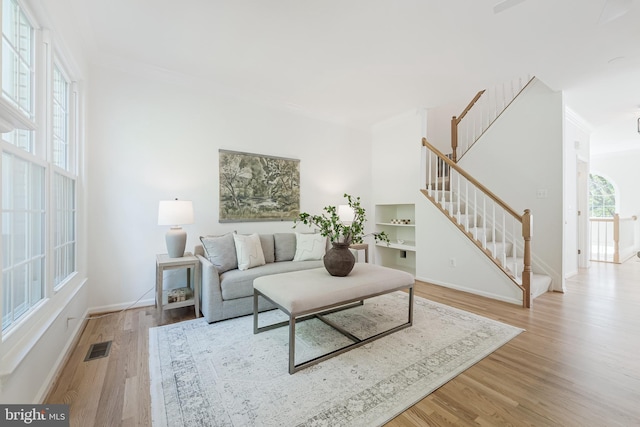 1251 Wild Hawthorn Way, Reston, VA 20194 - living room featuring ornamental molding, light wood-style floors, stairs, and baseboards