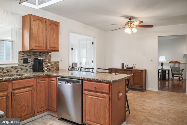 102 Gardengate Rd, Camden Wyoming, DE 19934 - kitchen with dishwasher, a peninsula, a ceiling fan, decorative backsplash, and brown cabinets