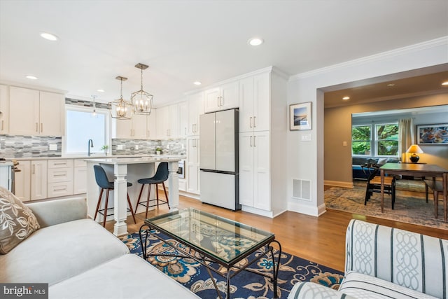 2709 Emmet Rd, Silver Spring, MD 20902 - living room featuring crown molding, light wood-style flooring, recessed lighting, a chandelier, and baseboards
