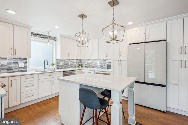 2709 Emmet Rd, Silver Spring, MD 20902 - kitchen featuring freestanding refrigerator, a chandelier, a sink, a kitchen bar, and white cabinetry