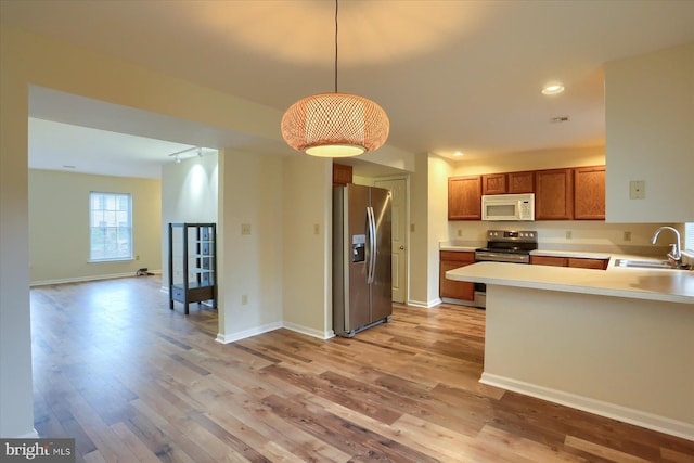 205 Saddle Ridge Dr, Harrisburg, PA 17110 - kitchen with appliances with stainless steel finishes, a sink, light wood finished floors, brown cabinetry, and light countertops